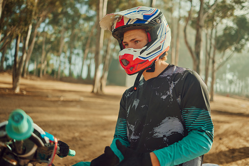 Motorcycle, motocross and nature with a sports man outdoor for an extreme ride on his dirtbike. Fitness, freedom and motorbike with a male athlete or rider in the forest for adrenaline or adventure