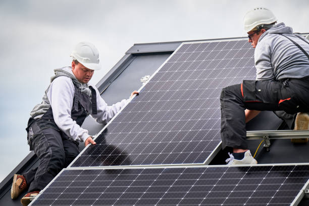 istock Men workers installing solar panels on roof of house. 1473449863