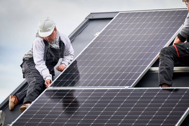 istock Men workers installing solar panels on roof of house. 1473449882