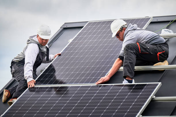 istock Men workers installing solar panels on roof of house. 1473449930