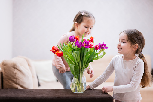 Two sisters with spring tulip bouquet.  Holiday decor with flowers colorful tulips.