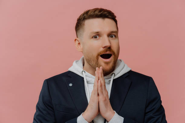 istock Excited man making wish, holding hands in praying gesture 1473451316