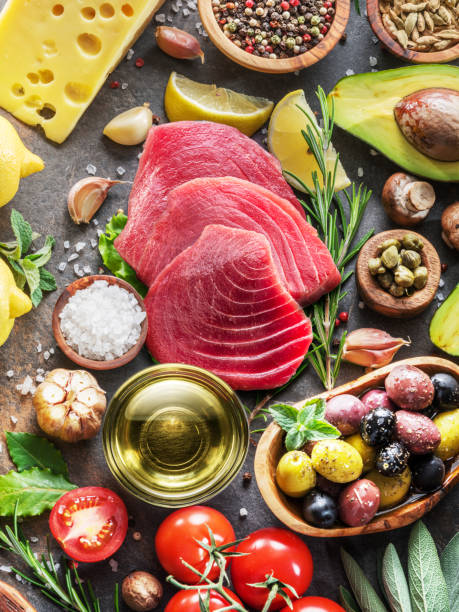 сырые стейки из тунца со специями и овощами на графитовой доске. средиземноморская кухня. вид сверху. - tuna steak tuna steak olive oil стоковые фото и изображения