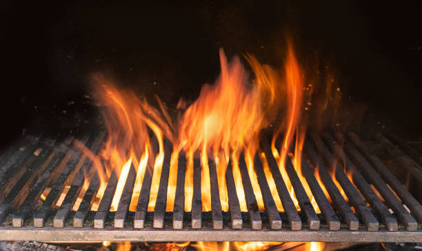 istock Barbecue grill with fire flames closeup on dark background. 1473452846