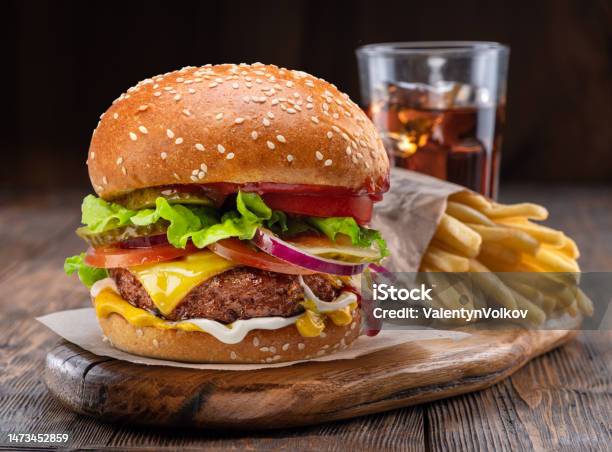 Tasty Cheeseburger Glass Of Cola And French Fries On Wooden Tray Closeup Stock Photo - Download Image Now