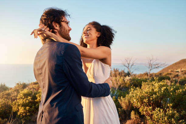 istock Love, wedding and bride with groom smile on mountain for marriage ceremony, commitment and celebration. Trust, happy and interracial couple relax on romantic holiday, honeymoon and vacation by ocean 1473454366