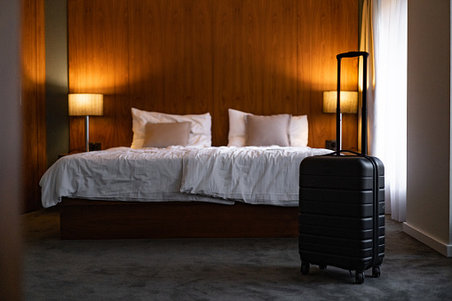 Black suitcase in a modern hotel room without people.