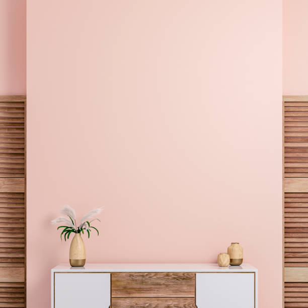 Cozy retro-chic interior with an art-deco cabinet and 50s- 60s decoration Cozy retro-chic interior with a low white and hardwood cabinet in front of a pastel light pink plaster wall background with copy space. Two hardwood containers, a vase with dry flowers on the white and a hardwood cabinet, with 2 hardwood slat doors on each side. The 50s- 60s decoration, art deco style. A slight vintage effect was added. 3D rendered image. art deco vase stock pictures, royalty-free photos & images