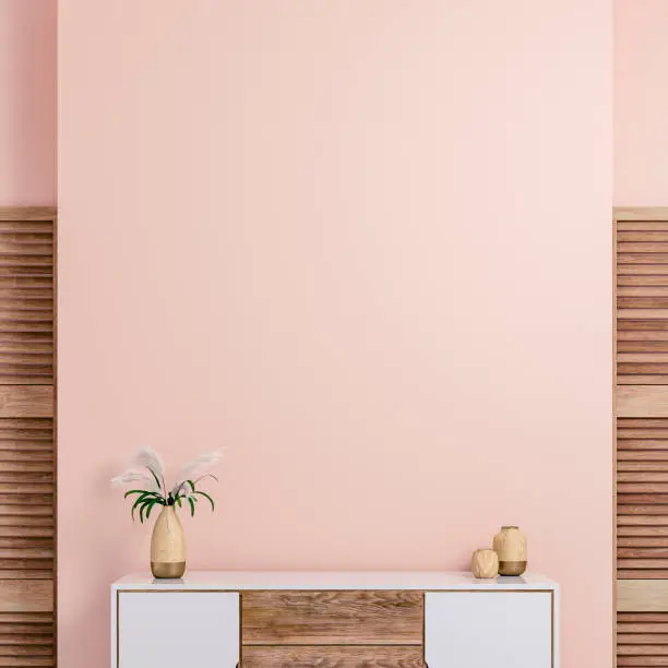 Cozy retro-chic interior with a low white and hardwood cabinet in front of a pastel light pink plaster wall background with copy space. Two hardwood containers, a vase with dry flowers on the white and a hardwood cabinet,  with 2 hardwood slat doors on each side. The 50s- 60s decoration, art deco style. A slight vintage effect was added. 3D rendered image.