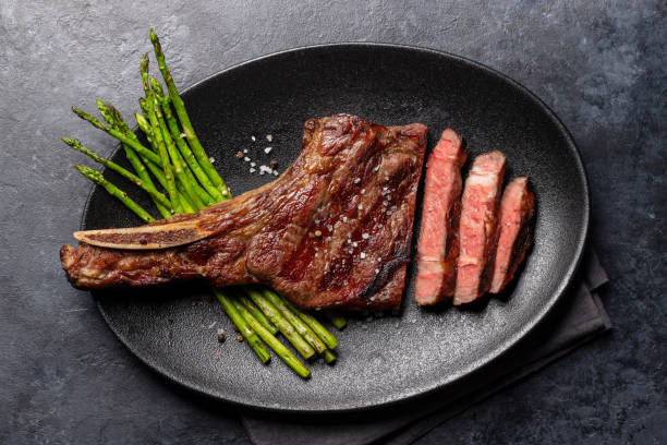 istock Medium rare grilled Tomahawk beef steak with asparagus 1473456748