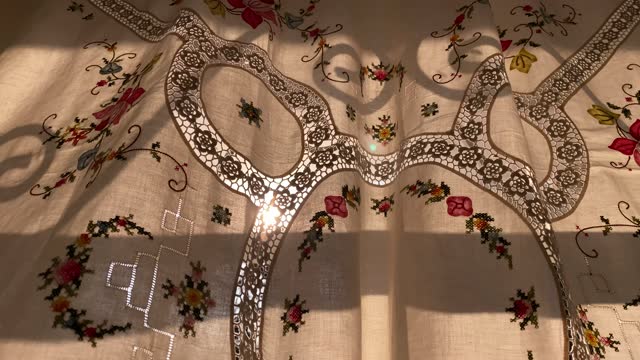 sunlight shining through the flower-patterned curtain