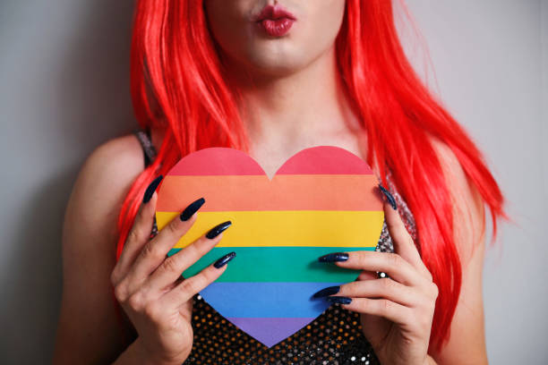 istock Kissy face unrecognizable transgender person holding a rainbow flag heart. 1473458007