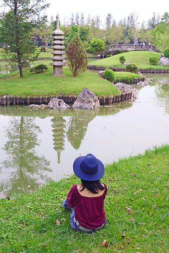 Woman in Blue Hat Relaxing in a Gorgeous Japanese Garden at Suanluang Rama9 Public Park, Bangkok, Thailand, ( Self Portrait )