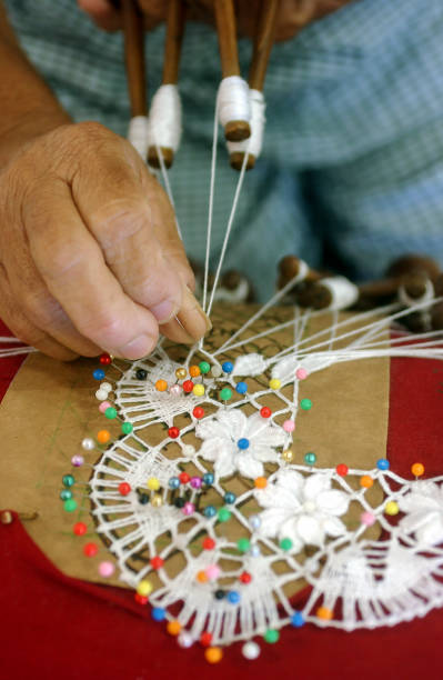 Handmade bobbin lace from northeast Brazil on August 08, 2003. Craftswoman's hands in close-up with blurred background. Brazilian crafts
