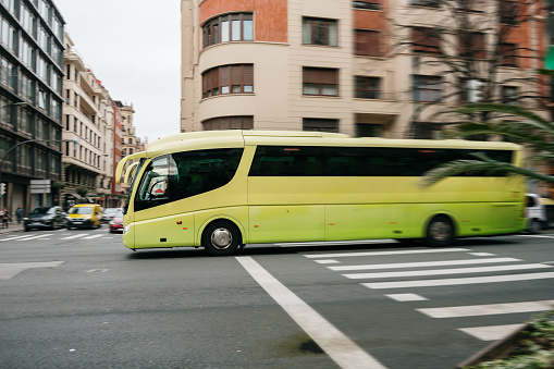 A modern coach bus in motion in a city