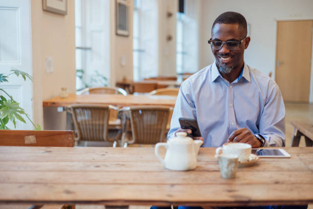 istock Businessman Using Phone in Coffee Shop 1473461905