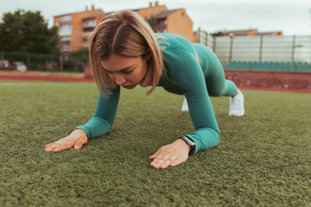istock Athletic woman training in plank position in stadium 1473464002