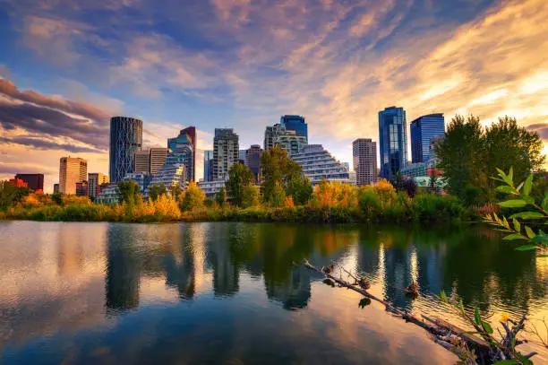 Sunset above city skyline of Calgary with Bow River, Alberta, Canada, photographed from Prince's Island Park.