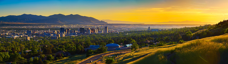 Panorama of Salt Lake City skyline at sunset with Wasatch Mountains in the background, Utah, USA.