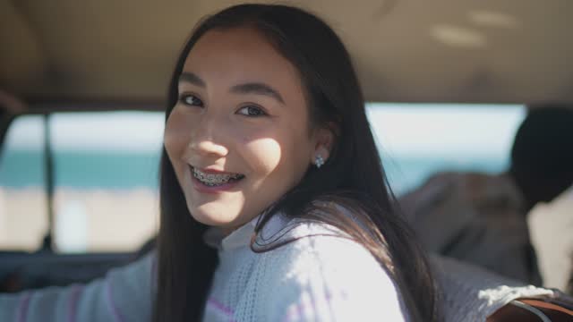 Portrait of young woman on a road trip driving mini van