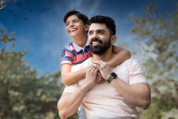 Loving father spending leisure time with son at park.