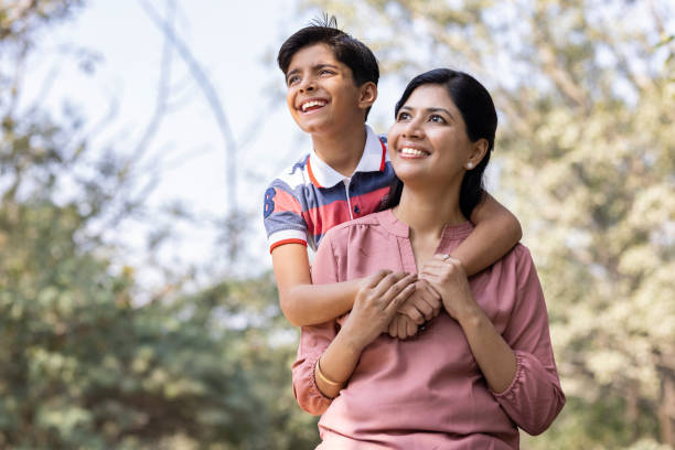 istock Cheerful mother and son having fun while admiring view at park. 1473466233