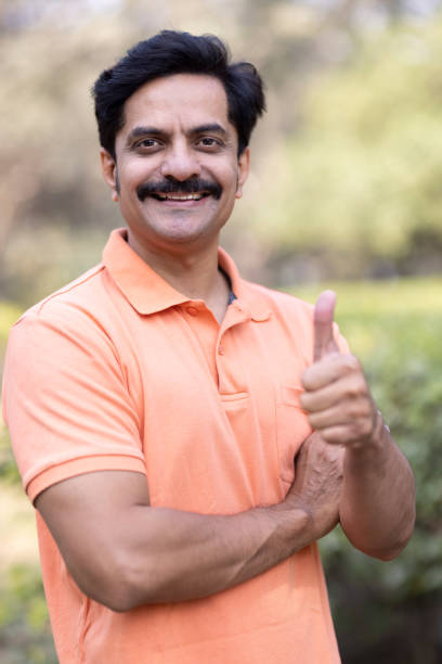 istock Confident man at park and showing thumb up 1473466987