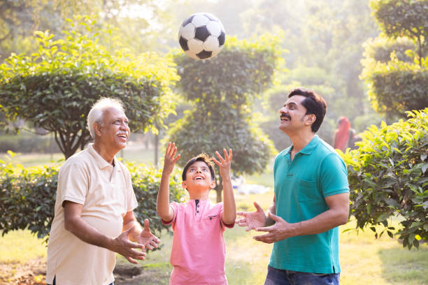 istock Three generation family having fun while playing with football at park. 1473469049