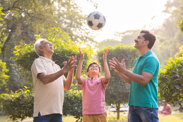 istock Three generation family having fun while playing with football at park. 1473469050