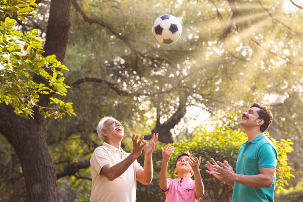 istock Three generation family having fun while playing with football at park. 1473469064