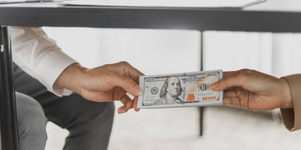 istock Business people giving dollar bribery for corruption contract. 1473469197