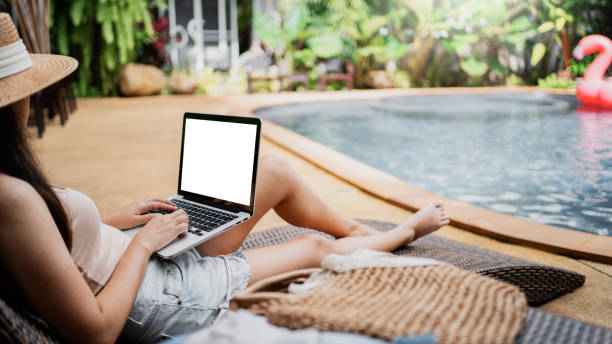 istock Female freelancer using laptop at swimming pool in holiday vacation. 1473469206
