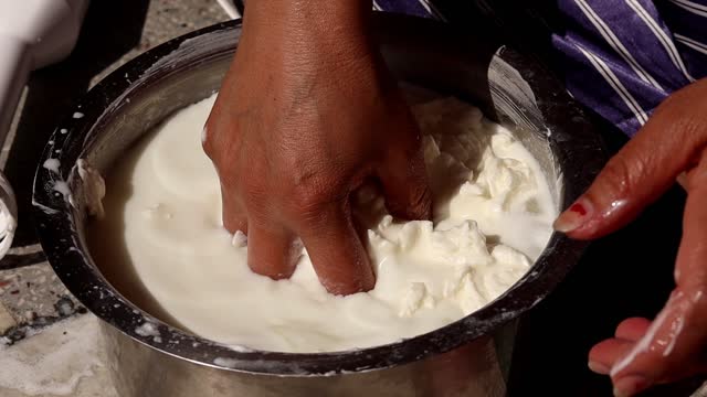 Closeup of Indian women hands making of Butter at home.