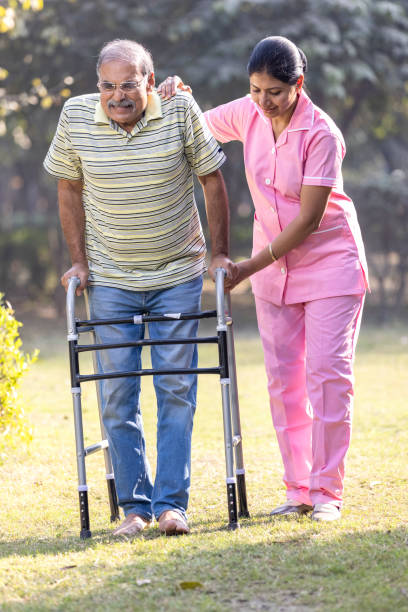 young asian woman nurse care giver helping senior old man with mobility walker in garden at home - aging process middle women men imagens e fotografias de stock