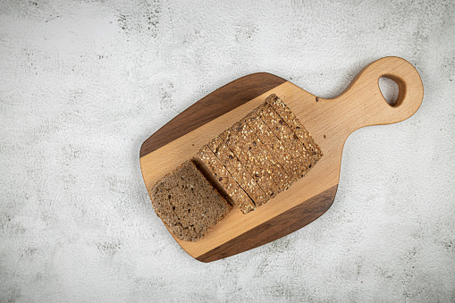 Top view healthy food sliced bread cereals wooden cutting board.