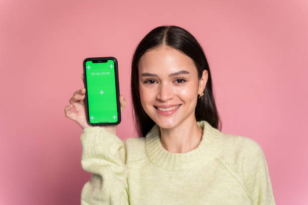 istock Smiling woman showing smartphone with croma screen 1473473522
