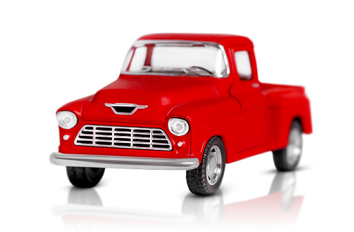 Isolated red toy car on white background with shadow and reflection