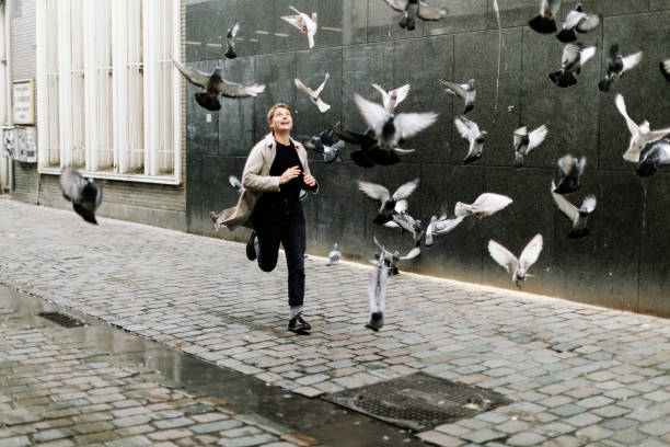 istock City pigeons taking flight as a happy girl runs quickly through them 1473481979