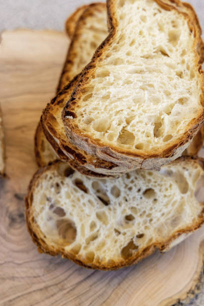 istock Fresh bread slices on wooden table. Concept of traditional leavened bread baking methods. Healthy food 1473484292