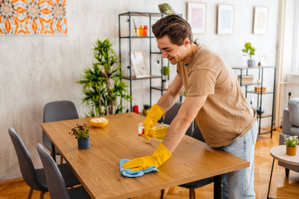 istock Young Man Cleaning His Dining Table At Home 1473485093