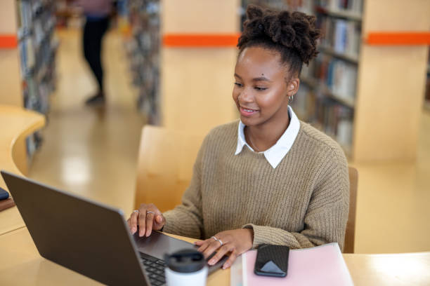 istock African-American Young Lady Reading Information On Her Laptop 1473485152