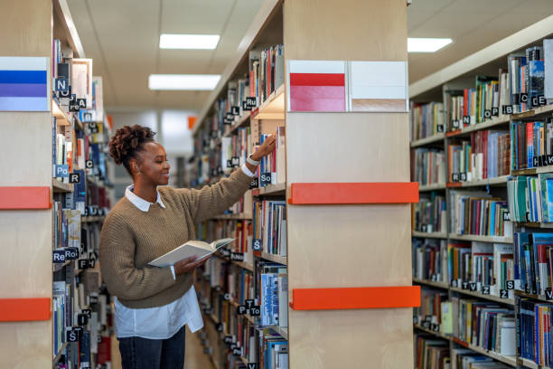 istock Female African-American Student Looking For A Book At The Library 1473485216