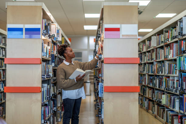 istock Female African-American Student Looking For A Book At The Library 1473485220