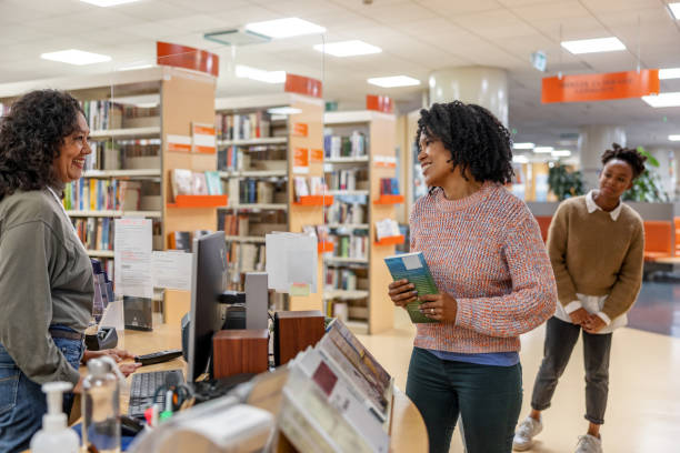 istock Multicultural Female Students On Line To Check Out Their Books At The Library 1473485252