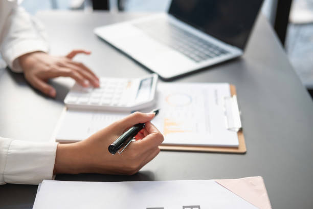 Marketing, Financial, Accounting, Planning, business women analyze company results and profits with graph statistics. Use a laptop computer and a calculator to calculate the company is balance. marketing, finanzas, contabilidad, planificación, las mujeres de negocios analizan los resultados y las ganancias de la empresa con estadísticas gráficas. use una computadora portátil y una calculadora para calcular el equilibrio de la empresa.