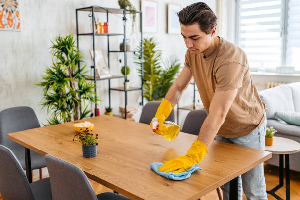 istock Young Man Cleaning His Dining Table At Home 1473485510