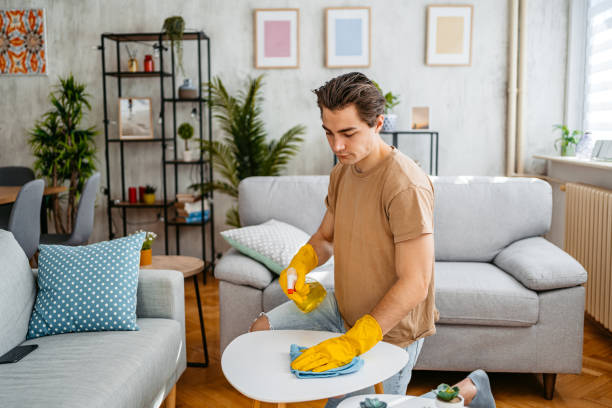 istock Young Man Cleaning His Coffee Table At Home 1473486134