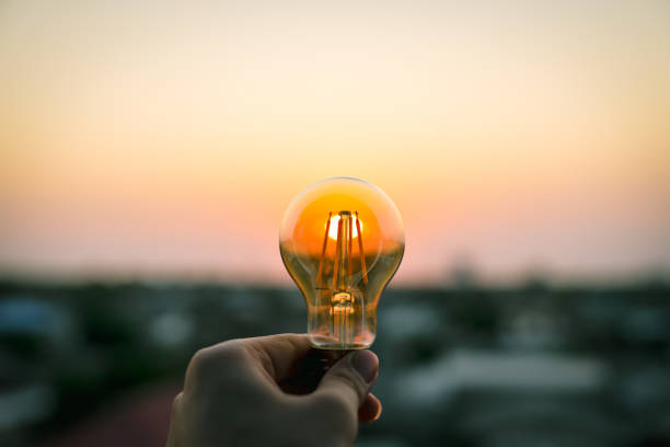 istock Hand business man holding light bulb. Alternative energy, idea, saving electricity innovation and inspiration concepts. 1473492321