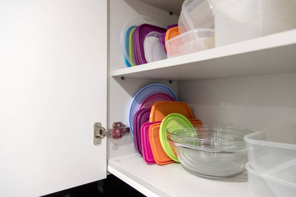 istock Open kitchen cupboard full of plastic and glass containers inside. 1473495564