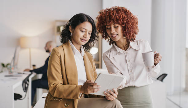 istock Office diversity, tablet and women teamwork on brand advertising, sales forecast or online data analysis. London app research, ui communication and collaboration review of customer experience survey 1473496312